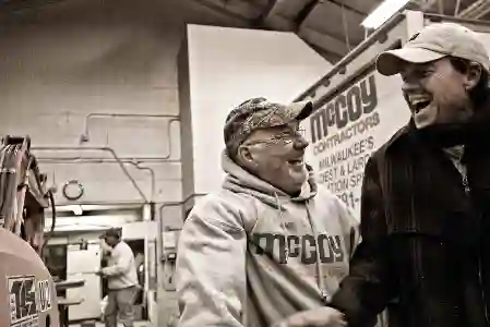 McCoy Contractors foreman and team joking around in shop - foundation repair professionals Milwaukee