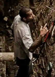 McCoy Contractors foundation repair crew looking up from excavation hole next to outside wall Milwaukee